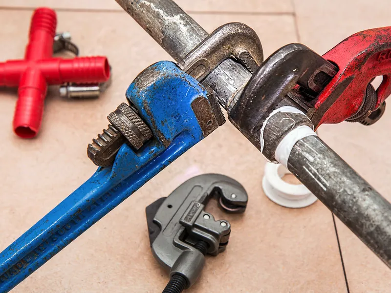 Pipe wrenches and a tubing cutter used for drain clearing work